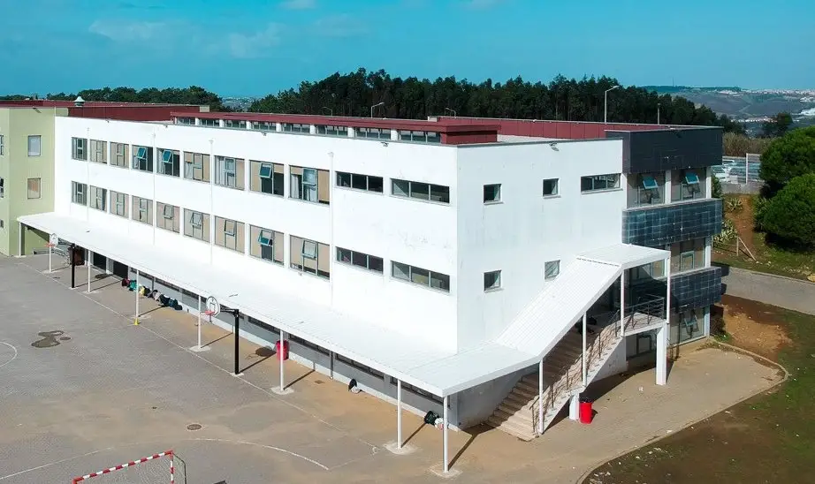 White classroom block with a covered walkway and outdoor stairs at Colégio Miramar