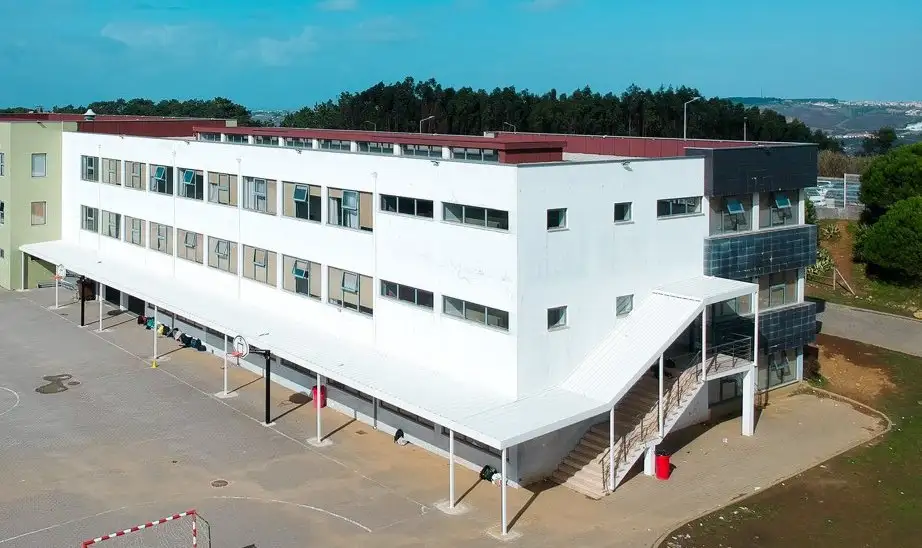 White classroom block with a covered walkway and outdoor stairs at Colégio Miramar