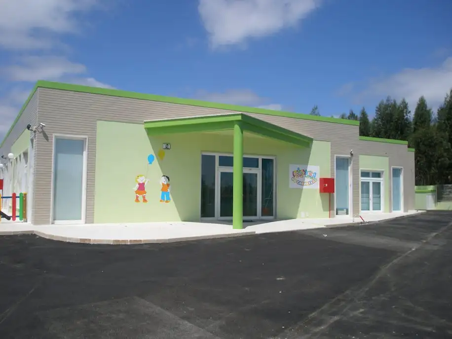 Green and grey single-storey building of Os Caramelos in Alcainça