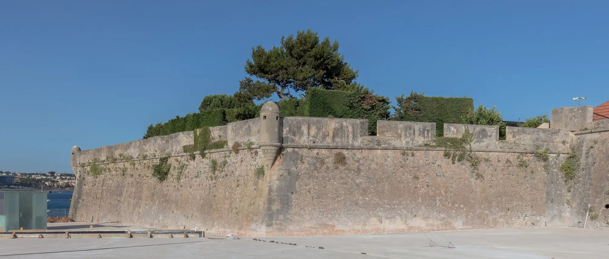 The old stone walls of the Cascais citadel under a blue sky
