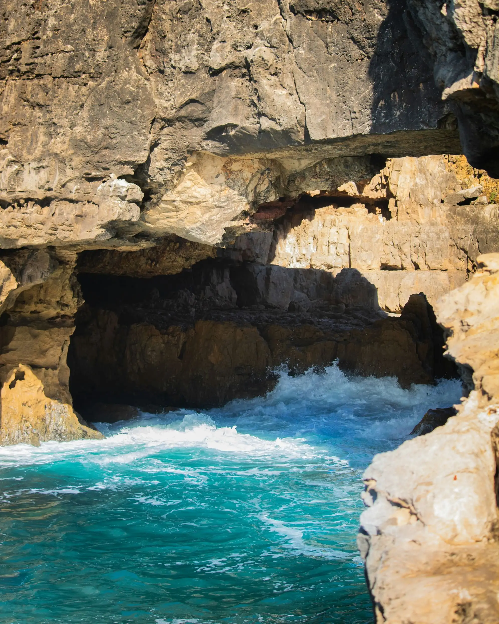 Turquoise sea beneath limestone cliffs on the Cascais coast
